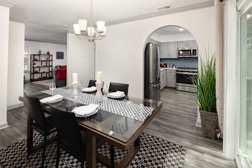 A modern dining room with a glass table and chairs.