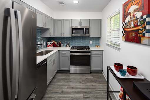 A modern kitchen with a refrigerator, microwave, oven, and dishwasher.