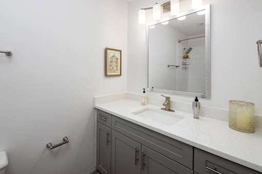 A bathroom with a white sink and a mirror above it.