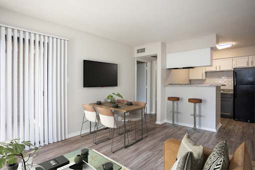 A modern living room with a dining table and chairs.