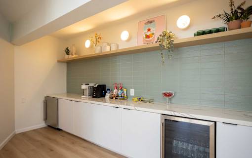 A kitchen with a white counter and a black fridge.
