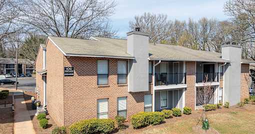 A brick building with a balcony on the second floor.