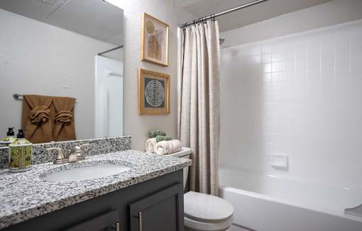 A bathroom with a toilet, sink, and shower.