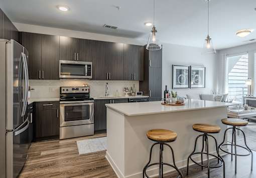 A modern kitchen with dark wood cabinets and stainless steel appliances.