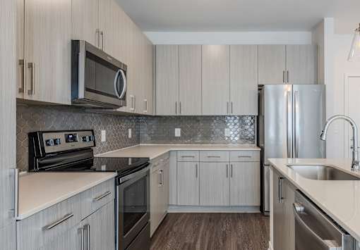 A kitchen with a black microwave above the stove.