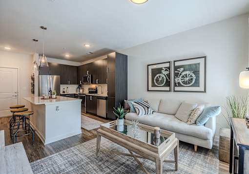 A modern kitchen with a white island and a bar stool.