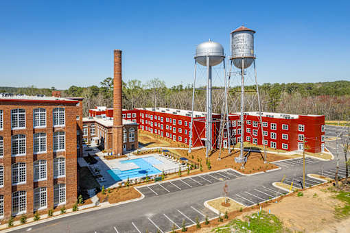 A red brick building with a water tower and a pool.