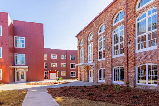A red brick building with a walkway in front.