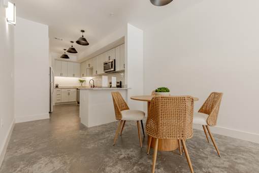 A kitchen with a table and chairs in the foreground.