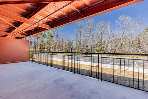 A parking lot is visible through a fence.