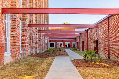 A long corridor with a red roof and brick walls.