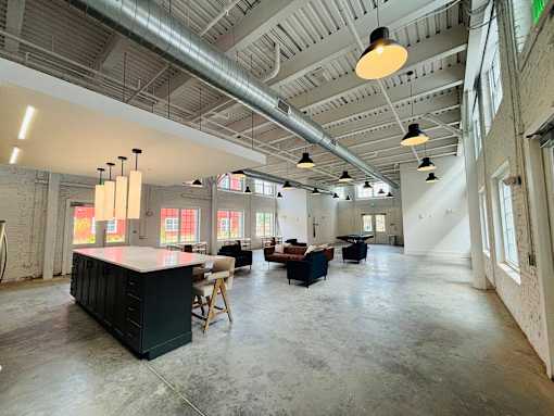 A large open space with a kitchen island and multiple seating areas.