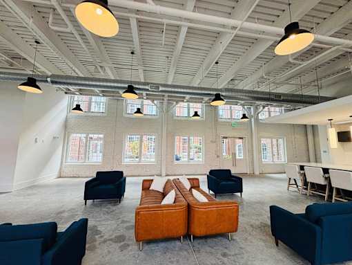 A large room with a long couch and chairs.