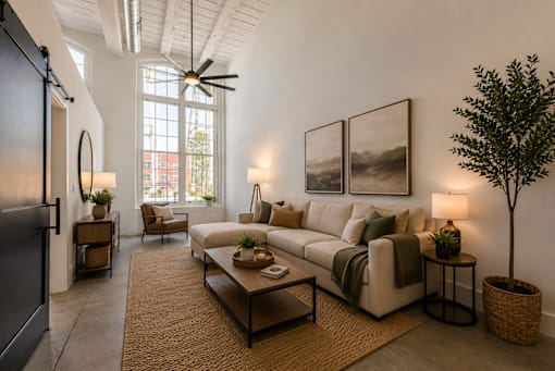 A living room with a couch, a chair, a table, and a potted plant.