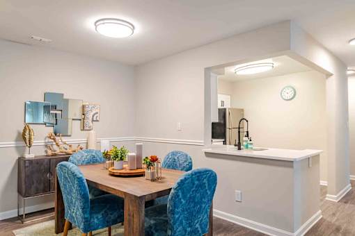A dining room with a wooden table and blue chairs.