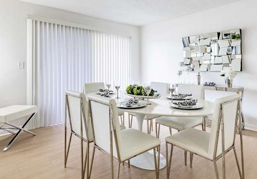 A modern dining room with a white table and chairs at Waterview at Rocky Point, Tampa, FL