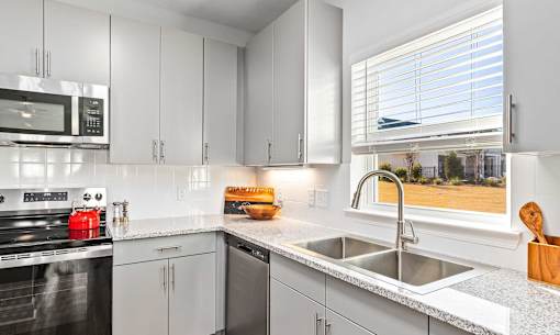 A kitchen with white cabinets and a black stove top oven.