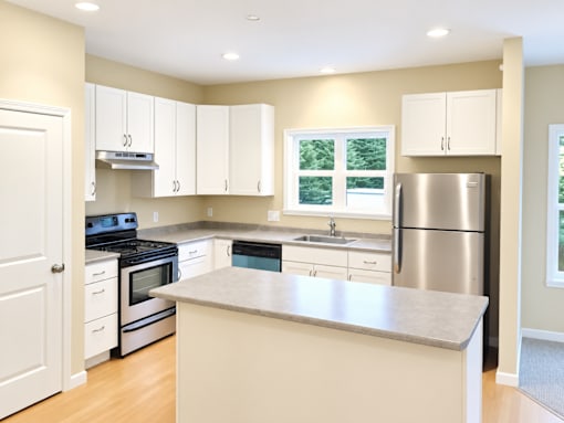 A kitchen with white cabinets and stainless steel appliances.