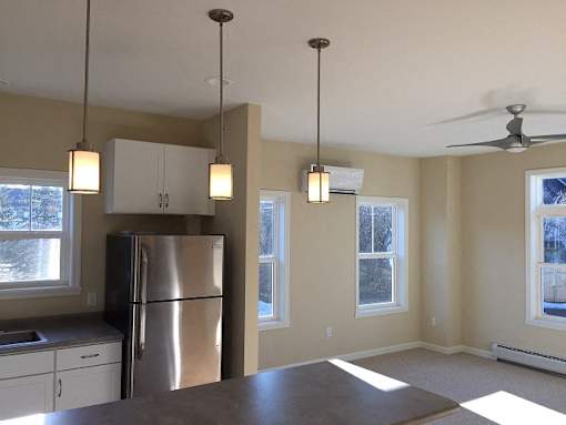 Hayes Kitchen facing living room with overhead light fixtures and four exterior windows