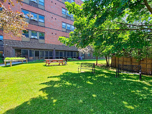 McKenzie House lawn in summer with picnic tables, benches and resident garden boxes