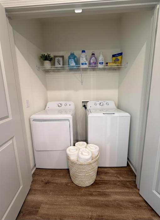 A small laundry room with a basket of towels in front of the washer and dryer.