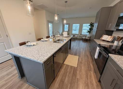 A kitchen with a granite countertop and wooden flooring.