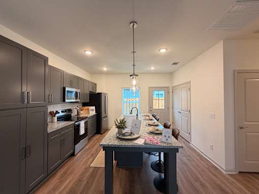 A modern kitchen with dark brown cabinets and a central island.
