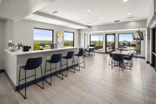 a large room with a bar and a view of the city