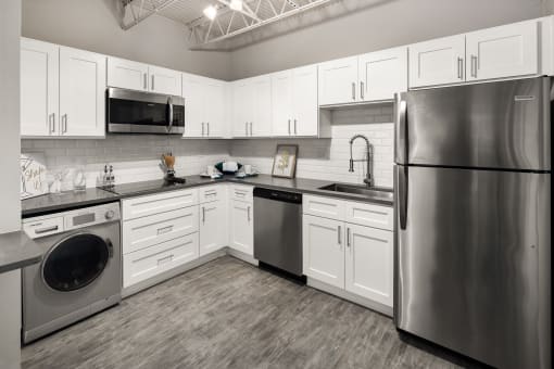 a kitchen with white cabinets and stainless steel appliances
