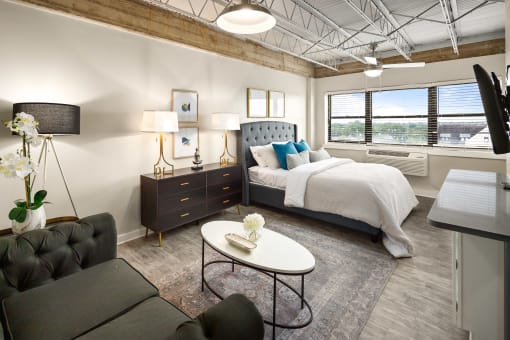 a bedroom with a bed and a desk in a room