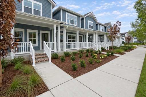 A row of houses with white front porches and steps.