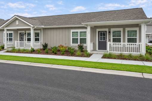 A house with a grey roof and white fence.
