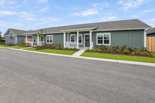 A row of houses with a grey front yard.