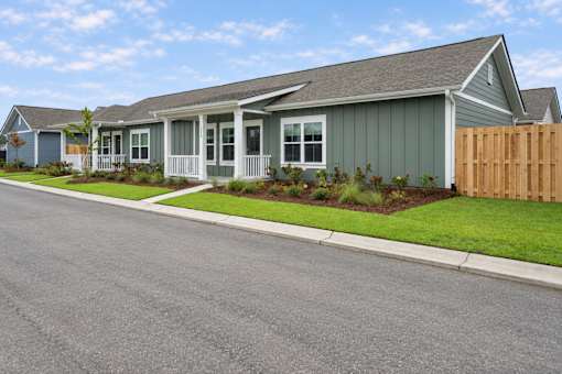 A house with a grey roof and a wooden fence.