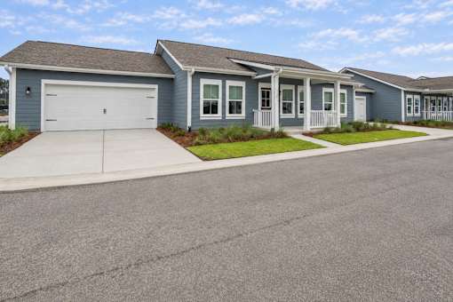 A row of houses with garages and front yards.