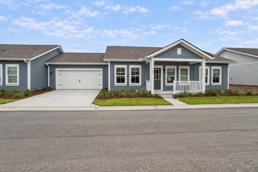 A house with a grey garage door and a white door.
