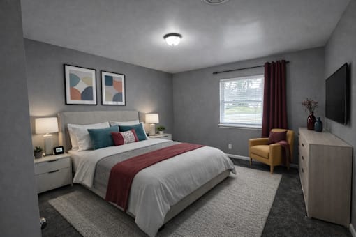 A bedroom with a large bed and a chair.