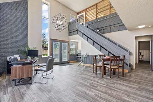 a living room with a dining room table and a staircase