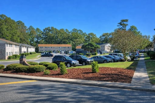 A street view of a residential area with cars parked on the side of the road.