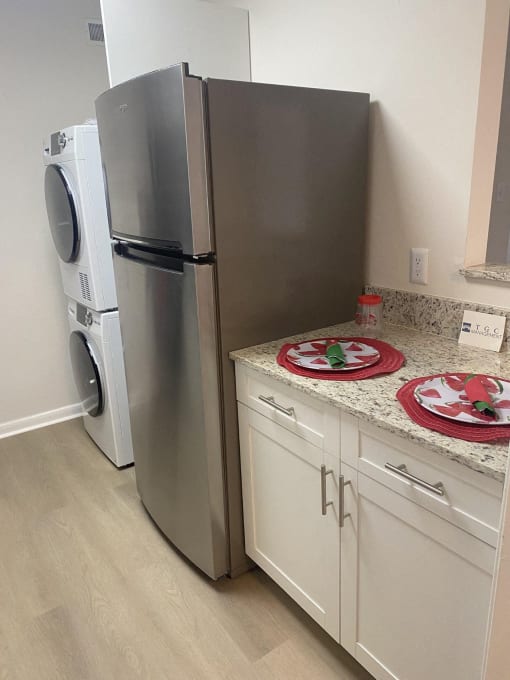 a kitchen with a counter and a refrigerator and a washing machine