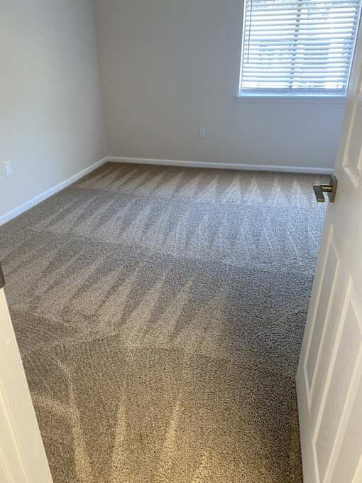 an empty room with a carpeted floor and a window