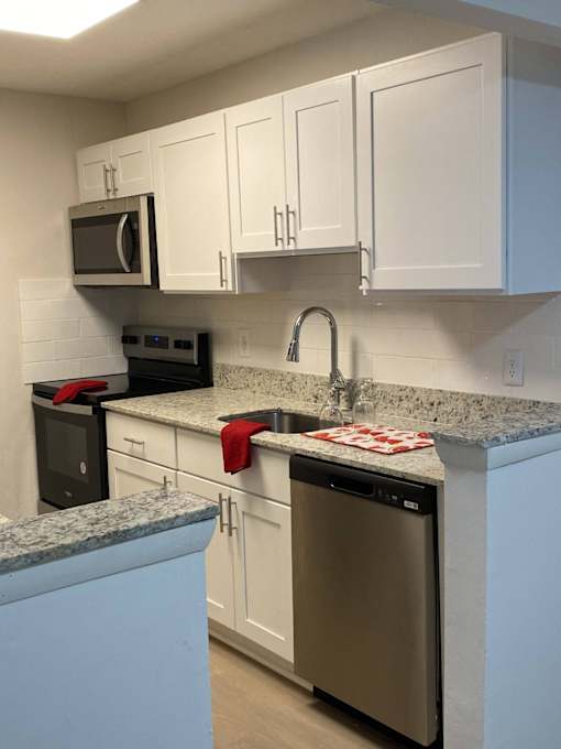 a kitchen with white cabinets and granite counter tops
