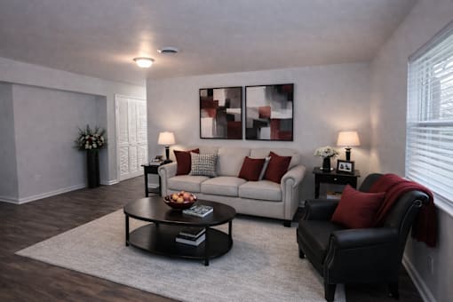 A living room with a grey couch, a black chair, and a coffee table.