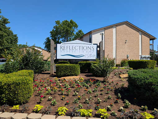 A sign for Reflections at Keefe is in front of a building.