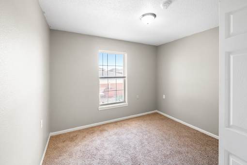 A room with a window and carpeted floor.