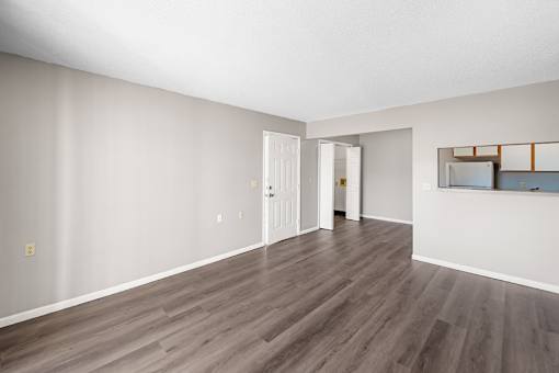 A room with wooden flooring and white walls.