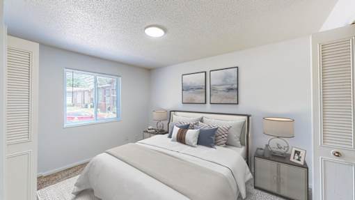 A bedroom with a large bed and a window overlooking a street.
