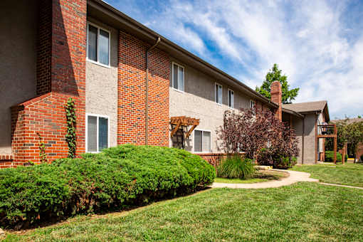 A red brick building with a green lawn in front.