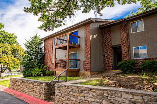 A red brick apartment building with a balcony on the second floor.