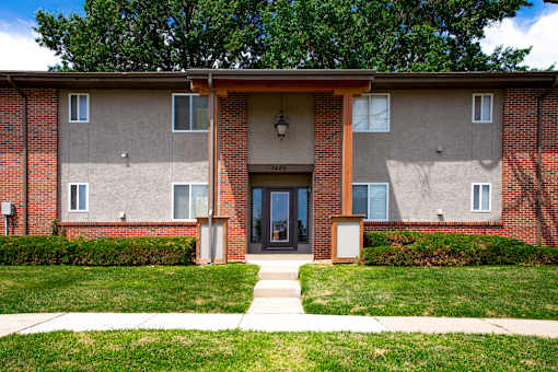 A brick building with a front door and windows.